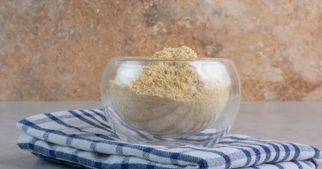 Poudre de racine d’ashwagandha dans un bol en verre, la plante étudiée pour la testostérone chez l’homme